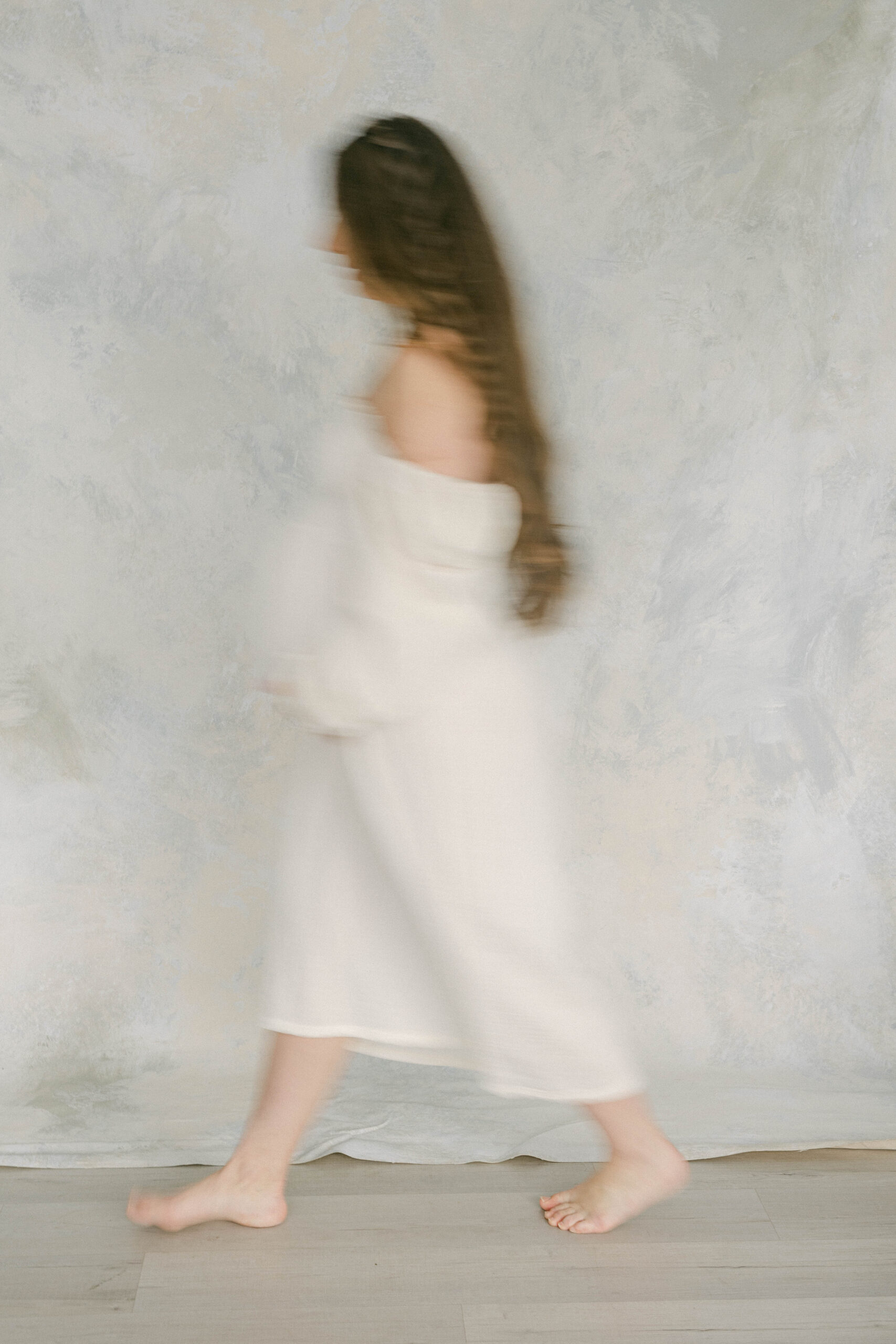 knoxville maternity photographer blurry women walking in front of fine art backdrop