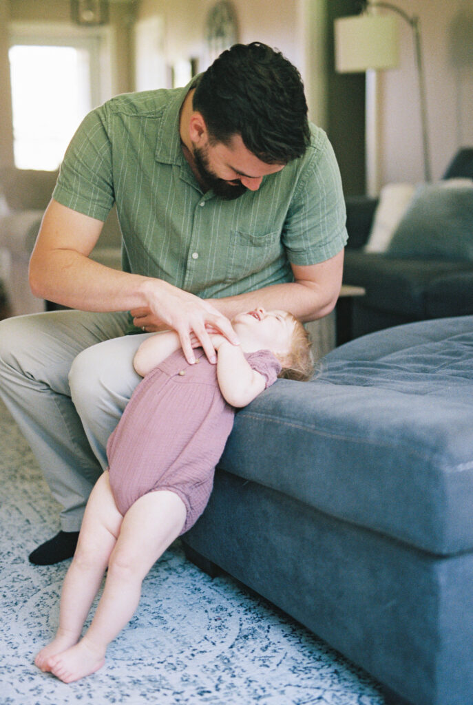 Natural in-home family photos of parents and child in Knoxville Tennessee candid laughing tickles