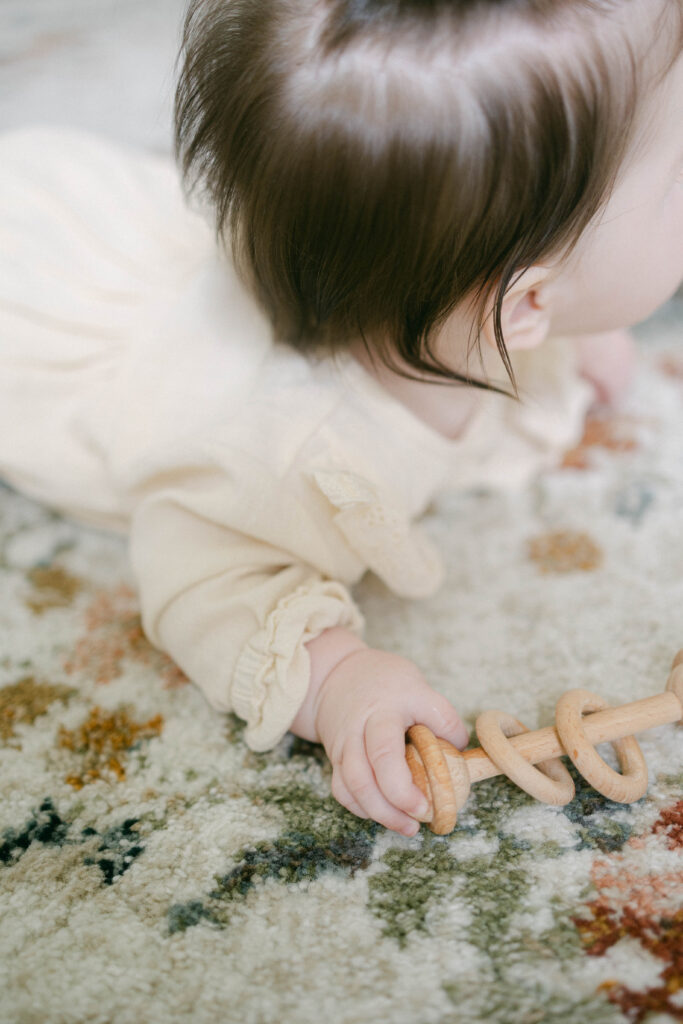 Close-up of baby's hand in natural window light during a Knoxville in-home milestone session.