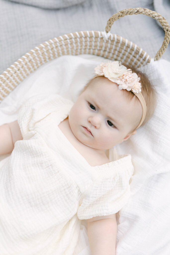 milestone session of six month old baby laying in basket lifestyle knoxville photographer